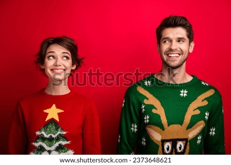 Photo of pretty tricky married couple wear ornament sweaters looking each other isolated red color background