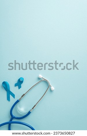 Emphasize importance of men's health month with top view vertical image displaying blue ribbons and a stethoscope for health examinations on a pastel blue background, offering space for text