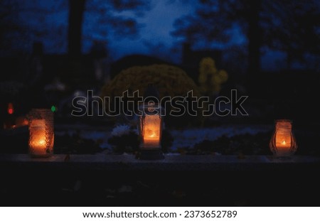 Votive candles lantern burning on the graves in Slovak cemetery at night time. All Saints' Day. Solemnity of All Saints. Hallows eve. 1st November. Feast of Saints. Hallowmas. Souls' Day in Slovakia Royalty-Free Stock Photo #2373652789
