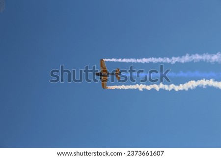 A low angle shot of a RC airplane flying in a cloudless blue sky Royalty-Free Stock Photo #2373661607