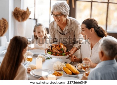 Thanksgiving Day, Autumn feast. Happy family sitting at the table and celebrating holiday. Grandparents, mother and children. Traditional dinner. Royalty-Free Stock Photo #2373666049