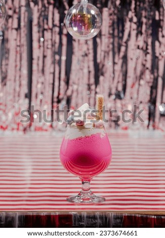 A closeup of a vibrant  fresh cocktail on a surface with a colorful background