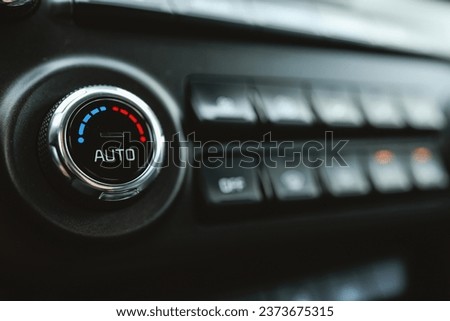 Modern car climate control panel for driver and passenger with shallow depth of field. Zone climate control. Car interior detail.