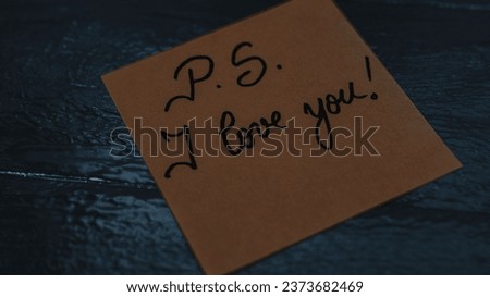 Text P.S. I love you on memo post reminder. Writing on sticky paper. Black and white photo. Bucharest, Romania, 2020.