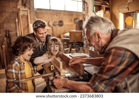 Young future carpenters learning the ways of their elders in a wood shop