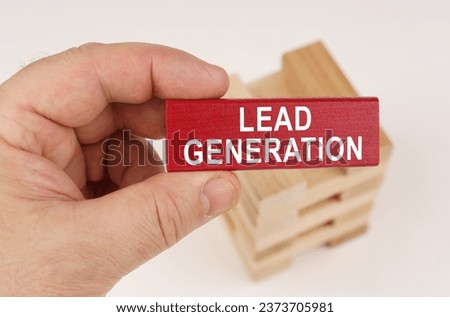 Business concept. In the hands of a man there is a red wooden plate with the inscription - Lead generation