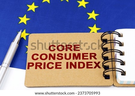 Economy and finance concept. On the flag of the European Union lies a pen and a notepad with the inscription - core consumer price index. Royalty-Free Stock Photo #2373705993