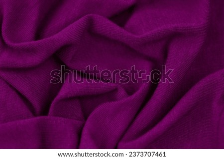 A close up shot of a cotton fabric in a vibrant purple hue, featuring a subtle, lightly-colored image