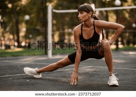 A young, athletic woman is exercising on the sports field. The concept of weight loss. Beautiful figure. Fintes exercises. Training in the open air. High quality photo