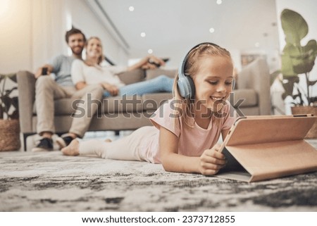 Child, headphones and tablet on floor in home education, listening to audio and streaming with parents in living room. Happy girl kid with digital e learning, video games and school or family holiday