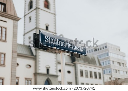 A blank street sign affixed to a tall metal pole located in a bustling urban area.