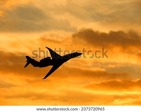 Silhouette of a private executive jet taking off against a winter sky at sunset. No people. Copy space.  Royalty-Free Stock Photo #2373720965