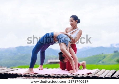 young girls is doing yoga training on balcony of resort with rice terraces, Ban Pa Bong Piang and mountains green over white sky in rainy season, Travel healthy lifestyle, enjoying in nature,