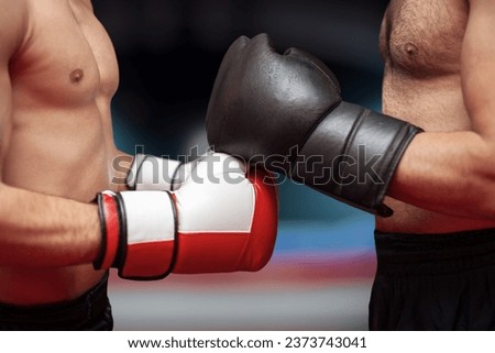 Two boxers before the start of a match in in front of blurry ring . Martial arts, fitness or MMA concept.  Fighters before the competition begins. Boxers greeting each other.