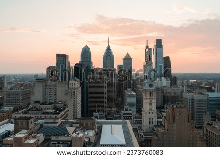 Aerial panoramic cityscape of Philadelphia financial downtown, Pennsylvania, USA. Philadelphia City Hall Clock Tower at sunset golden hour. A vibrant business and cultural neighborhoods.