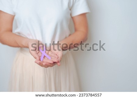 woman holding Purple Ribbon for Stomach, Violence, Pancreatic, Esophageal, Testicular cancer, Alzheimer, epilepsy, lupus, Sarcoidosis and Fibromyalgia. Awareness month and World cancer day concept Royalty-Free Stock Photo #2373784557
