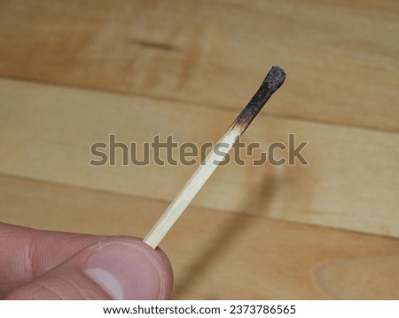 Hand holding a burnt unlit match macro picture closeup