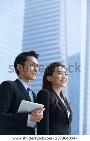 Portrait of Chinese business man and woman in a modern urban setting.  Royalty-Free Stock Photo #2373843947