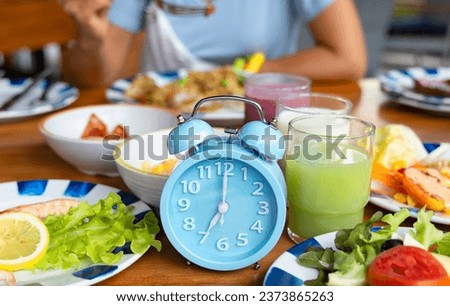 Woman diet plan with Blue  alarm clock with IF (Intermittent Fasting) 16 and 8 diet rule and weight loss concept.-Diet plan concept Royalty-Free Stock Photo #2373865263