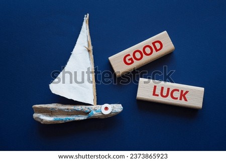Good luck symbol. Wooden blocks with words Good luck. Beautiful deep blue background with boat. Business and Good luck concept. Copy space.