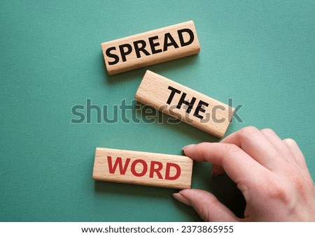 Spread the Word symbol. Concept wordsSpread the Word on wooden blocks. Beautiful grey green background. Businessman hand. Business and Spread the Word concept. Copy space.