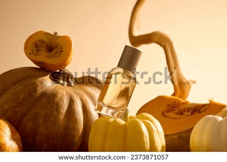 Mockup scene for advertising perfume product with Autumn concept. Front view of glass bottle without label displayed on pumpkins on backlit background. Minimalist art concept