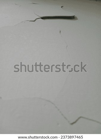 The cracks in the walls may have been made from cheap home building materials which caused the cracks to appear naturally