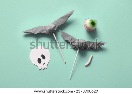 Sweet lollipops and jelly eye for Halloween party on turquoise background