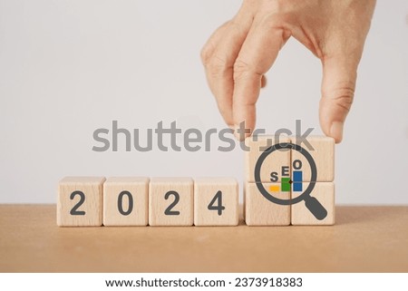 2024 wooden cube block with growing graph inside magnifying glass icon. SEO, Search Engine Optimization, hiring , Advertising, Idea, Strategy, marketing, Keyword, Content and New Year start concept