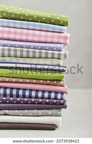Clean kitchen textiles made of cotton and linen - napkins, towels folded on the light background 