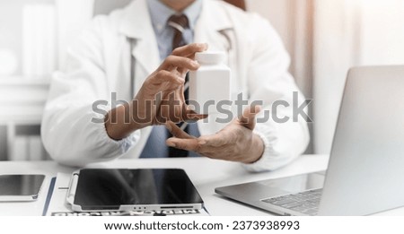 Pharmacists or doctors study information about medicine using laptop computer sitting at desk.