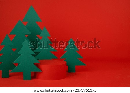 Christmas background - one cylinder podium, scene with 3d rendering for presentation gifts, cosmetics, goods in red color, green spruce forest, closeup. New year celebration template for advertising.