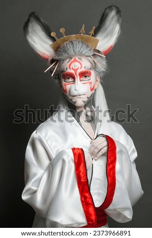 Woman bunny. Female model in animal mask on gray background. Halloween, Carnival and Cosplay concept