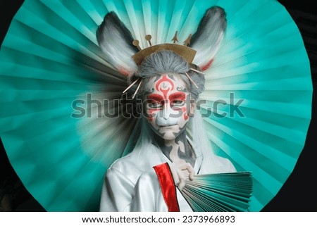 Colorful portrait of cute woman face in animal mask and creative makeup. Halloween, Carnival and Cosplay concept