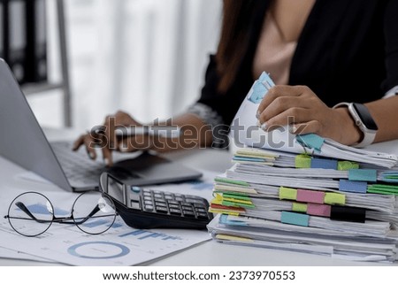 Businesswoman hands working in Stacks of paper files for searching and checking unfinished document achieves on folders papers at busy work desk office

