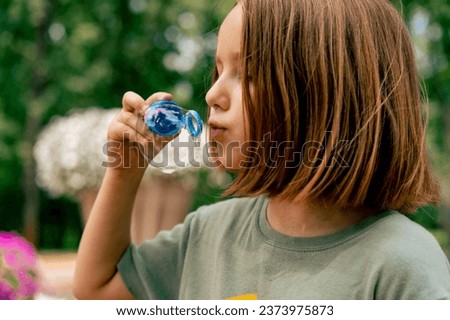 close-up portrait beautiful cute little girl blowing soap bubble in city park happy carefree childhood
