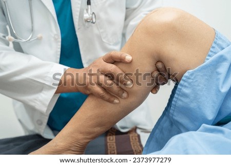 Asian elderly woman patient show her scars surgical total knee joint replacement Suture wound surgery arthroplasty on bed in nursing hospital ward, healthy strong medical concept. Royalty-Free Stock Photo #2373977279