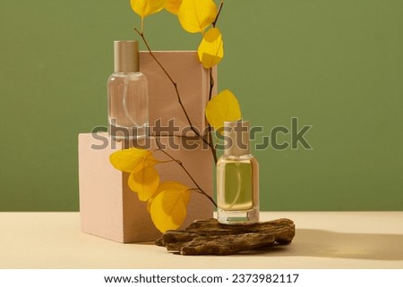Mockup scene for advertising perfume product with Autumn concept. Front view of two glass spray bottles without label displayed on cube podiums and stone with leaves on green background