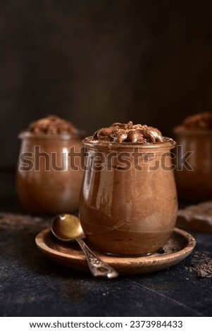 Delicious chocolate mousse in a vintage jars on dark slate, stone or concrete background.  Royalty-Free Stock Photo #2373984433