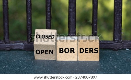Wooden cubes form the expressions 'open borders' and 'closed border'.