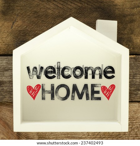 Welcome home sign on rustic wood