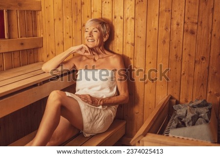 Mature woman is relaxing in sauna. Healthy lifestyle for elderly people. Spa concept. Royalty-Free Stock Photo #2374025413
