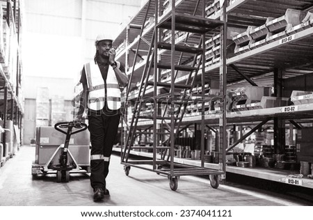 Young man pulling hand pallet truck loading package boxes stacked in shipping warehouse. Multiracial worker move merchandise from godown shelf by hand lift pallet jack. Delivery goods, cargo transport