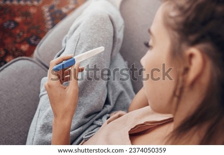 Pregnancy test, waiting and woman on sofa in home, reading news and check results.,Stick, sad and pregnant mother in living room for future maternity, ivf fertility and anxiety, depressed or serious Royalty-Free Stock Photo #2374050359