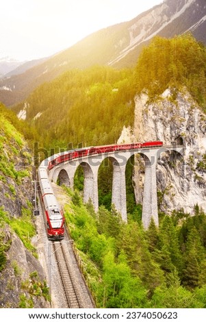 Swiss red train on viaduct in mountain, scenic ride Royalty-Free Stock Photo #2374050623