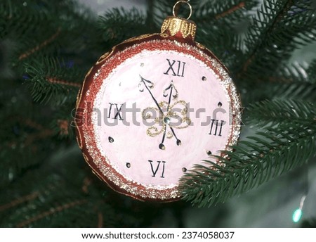 Ornament in the form of a clock on a Christmas tree.                   