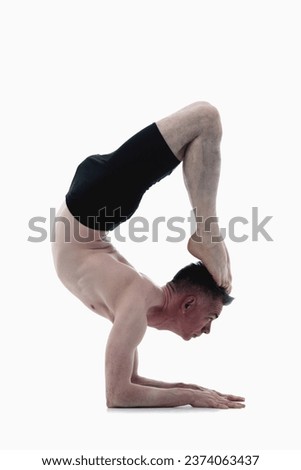 Scorpion Pose (Vrschikasana), Ashtanga yoga  Side view of man wearing sportswear doing Yoga exercise against white background. 