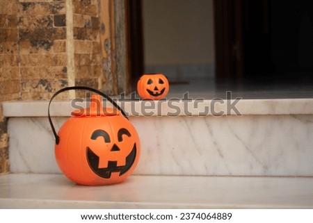 Halloween pumpkings at the door and hanging on of a kid hand.