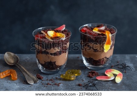 Graveyard dirt chocolate cups with  gummy worms, sweet and funny dessert for Halloween party
