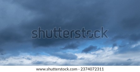 Autumn brings overcast skies adorned with gray stratus clouds, hinting at impending rain. This full-screen view provides ample space for text or design elements, making it perfect for various projects Royalty-Free Stock Photo #2374072311